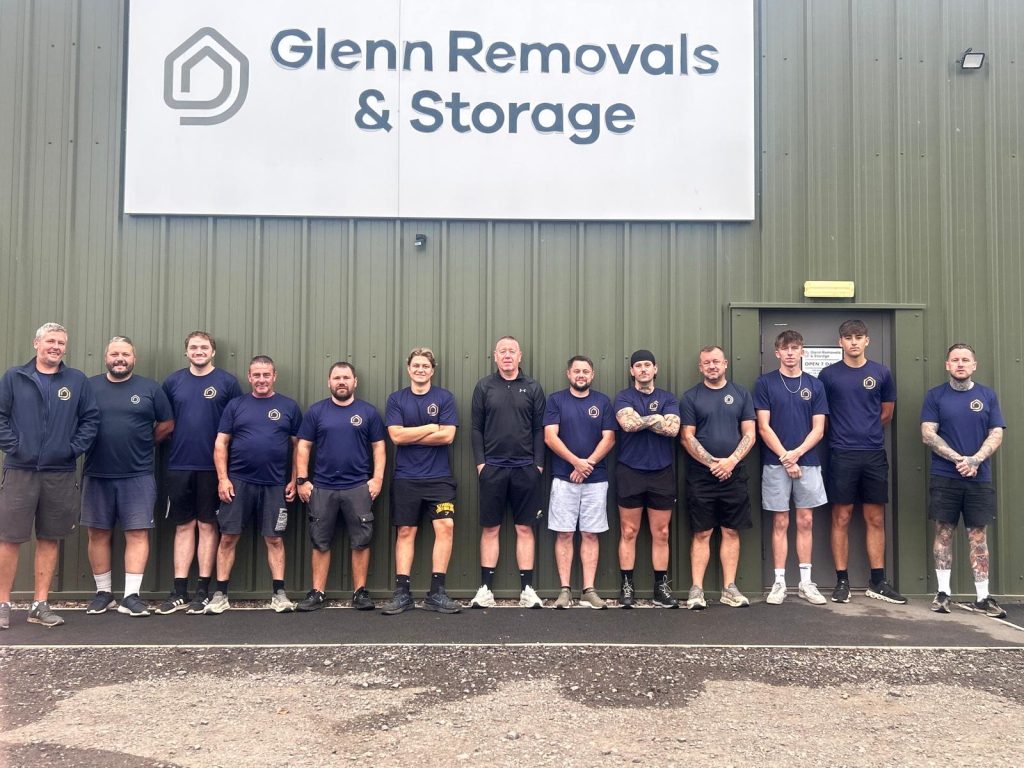 Glenn Removals and Storage team standing together outside their removals unit in Nuneaton