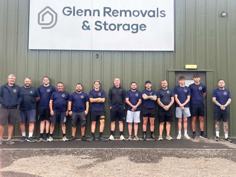 Glenn Removals and Storage team standing together outside their removals unit in Nuneaton